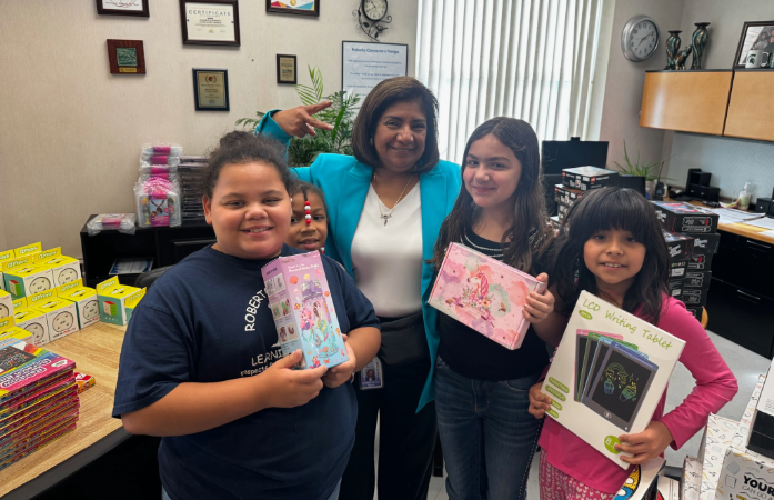 students posing with the principal and holding their prizes